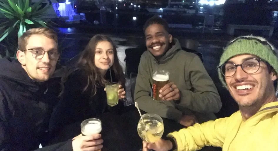 Four travelers raising their glasses at night in Ponta Delgada